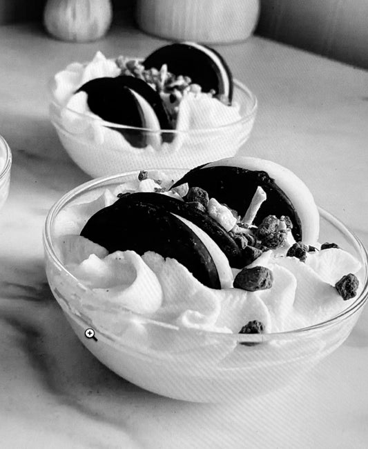 A candle designed to look like a sundae with layers of chocolate, vanilla, and cookies and cream scented wax, complete with hand-piped whipped wax and cookies and crean embeds and crumbles on top.