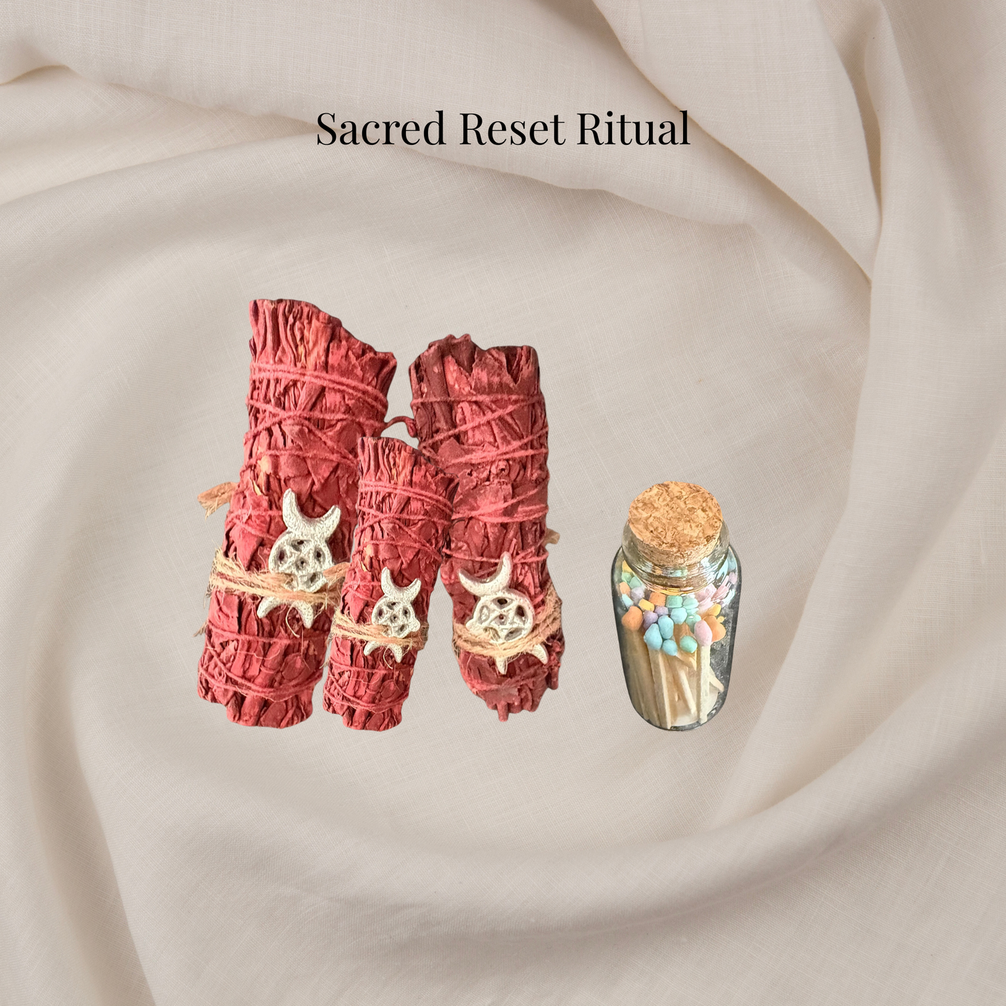 Two red smudge sticks with decorative elements on a beige fabric background, labeled 'Sacred Reset Ritual'.