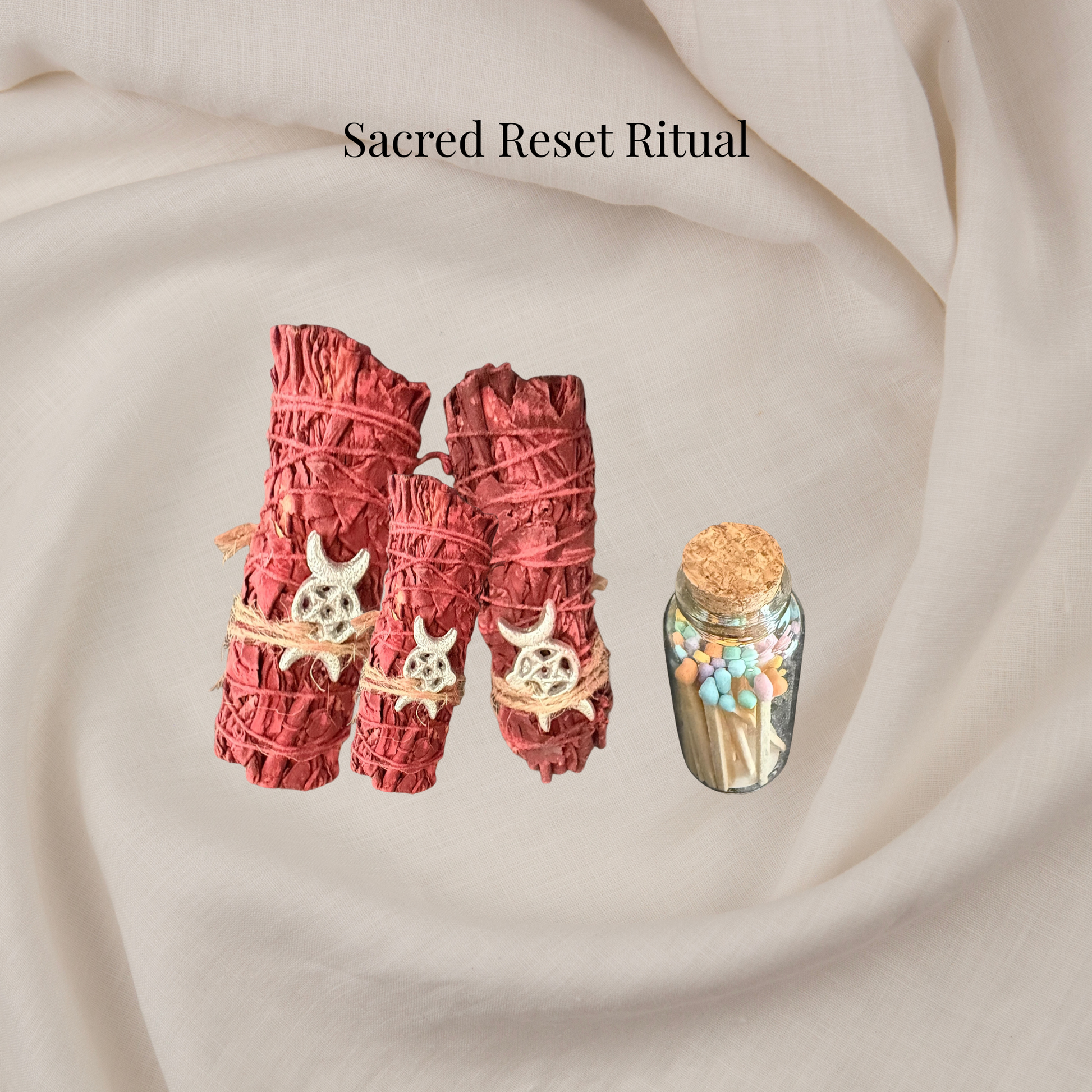 Two red smudge sticks with decorative elements on a beige fabric background, labeled 'Sacred Reset Ritual'.